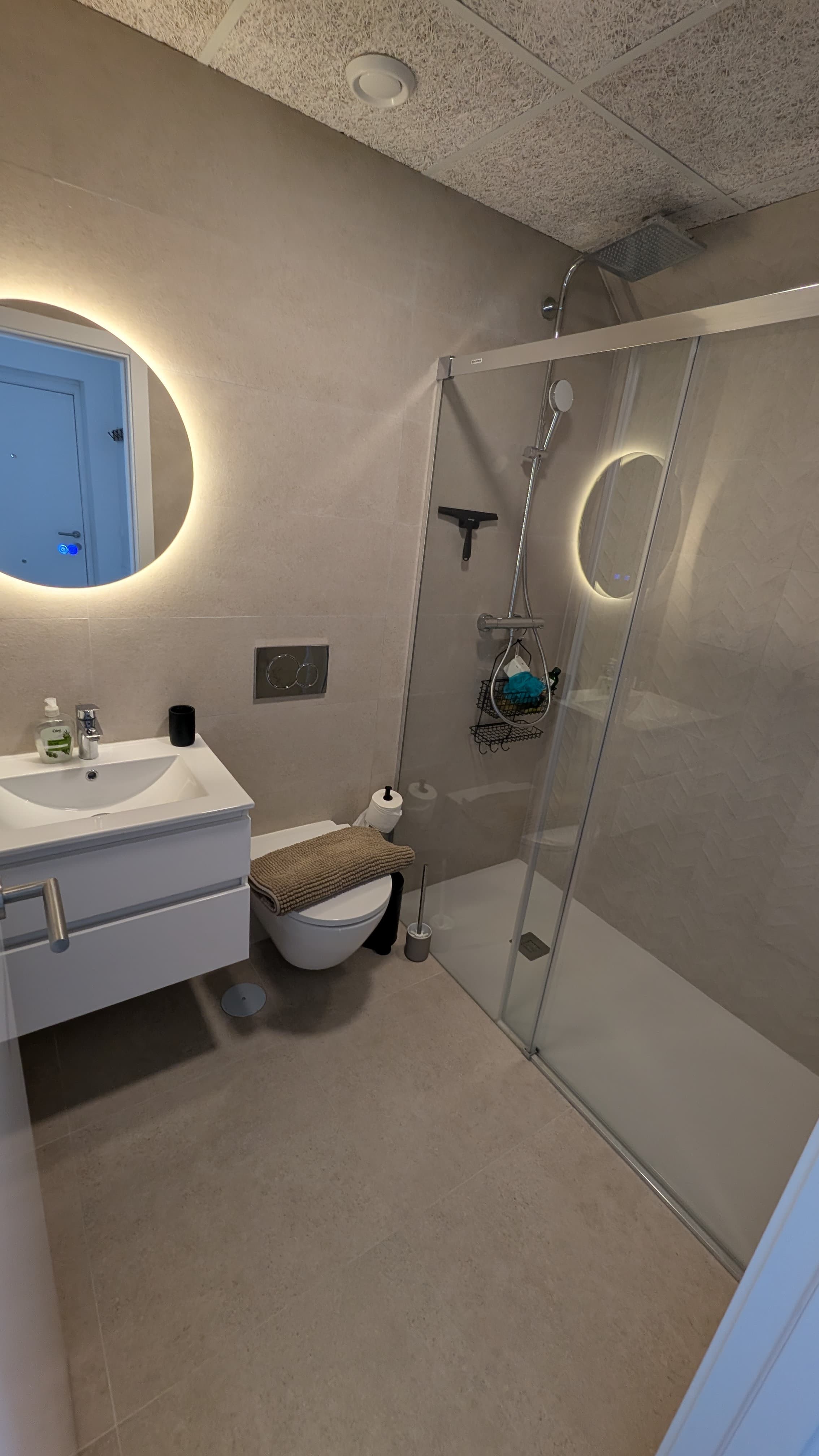 Bathroom with backlit mirror and walk-in shower