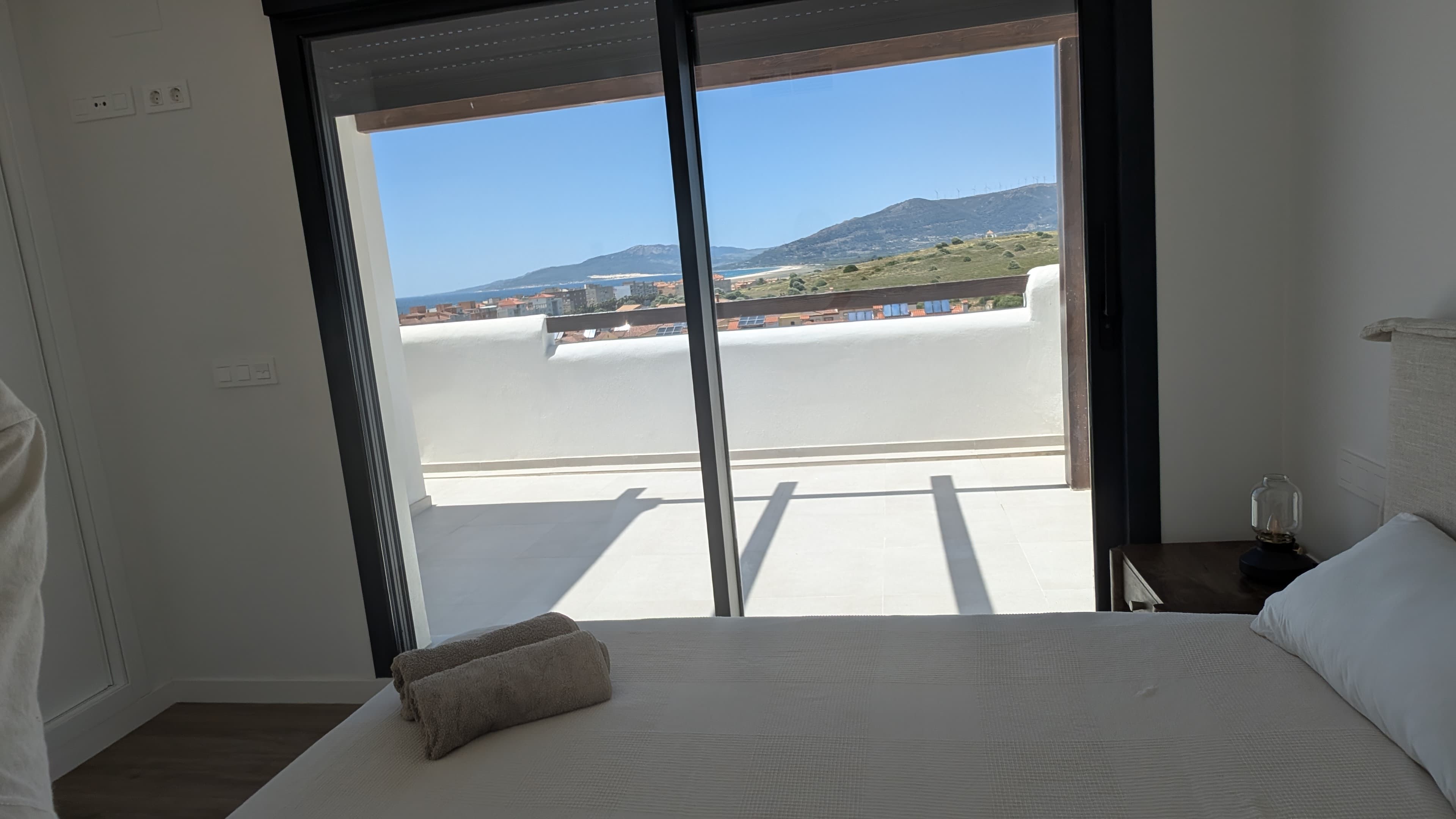 View from the main bedroom through sliding doors to the terrace and Tarifa rooftops