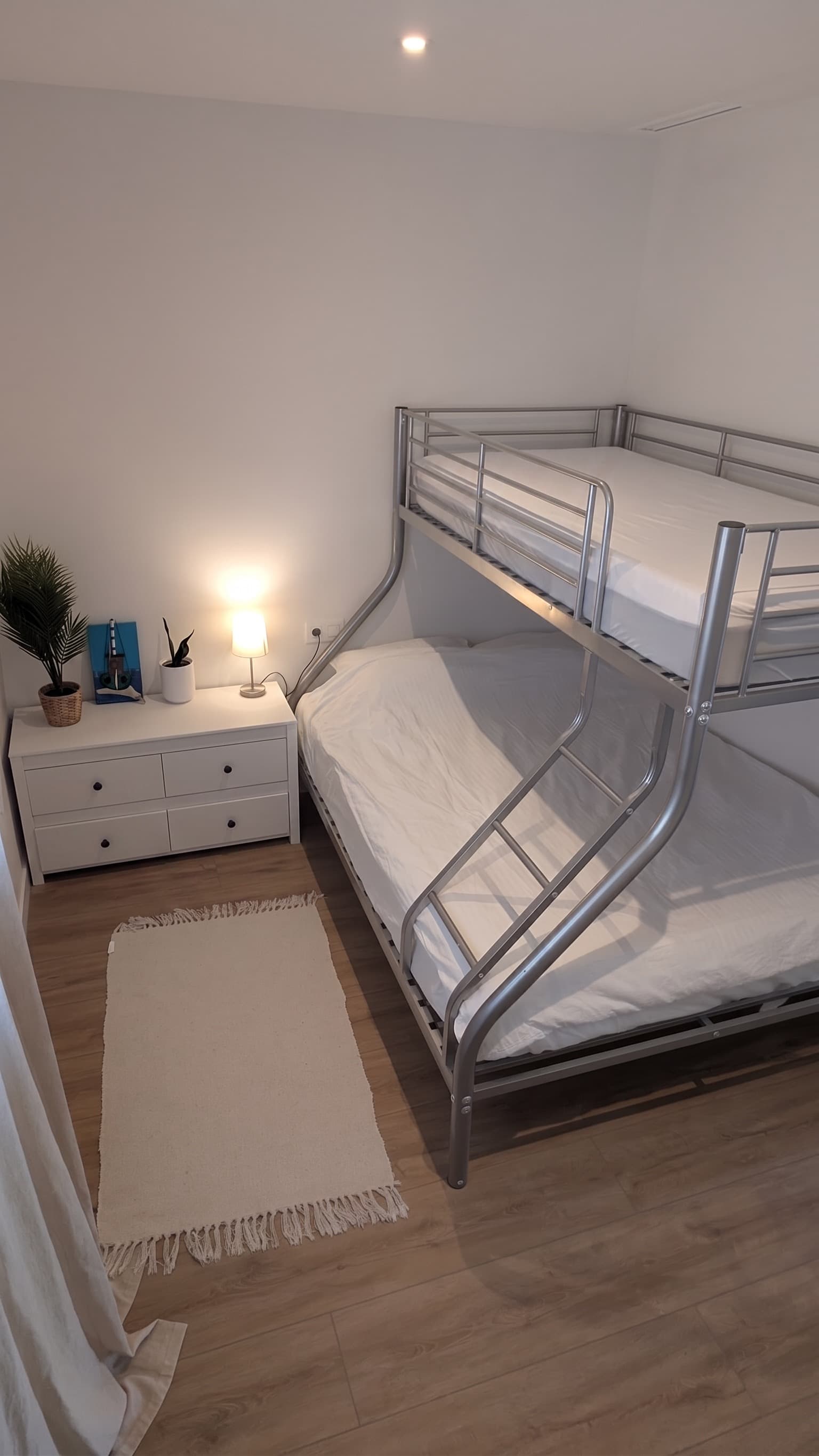 Second bedroom with triple bunk bed and warm lamp